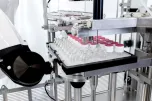 Robotic nest filling machine for vials with ARaymond caps
