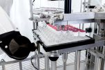 Robotic nest filling machine for vials with ARaymond caps